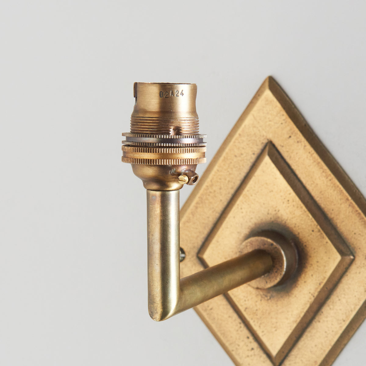 Close-up of the brass bayonet lampholder on the angled arm of the Diamond Angle wall light