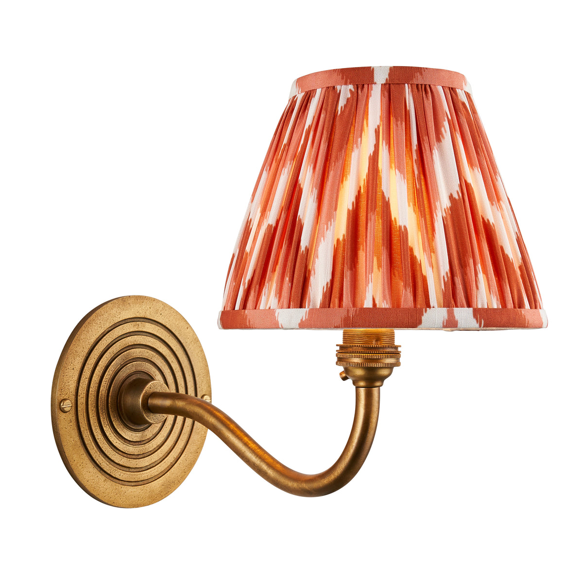 Ripple Curve antique brass wall light with orange and white ikat pleated shade on ribbed backplate