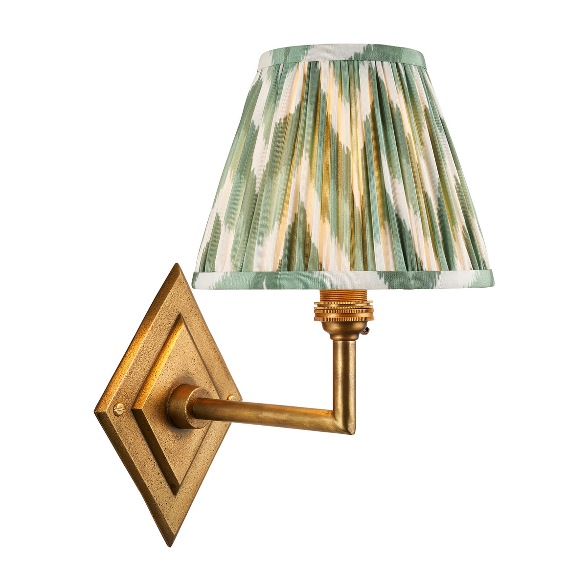 Diamond Angle antique brass wall light with a pleated green zigzag ikat shade, lit