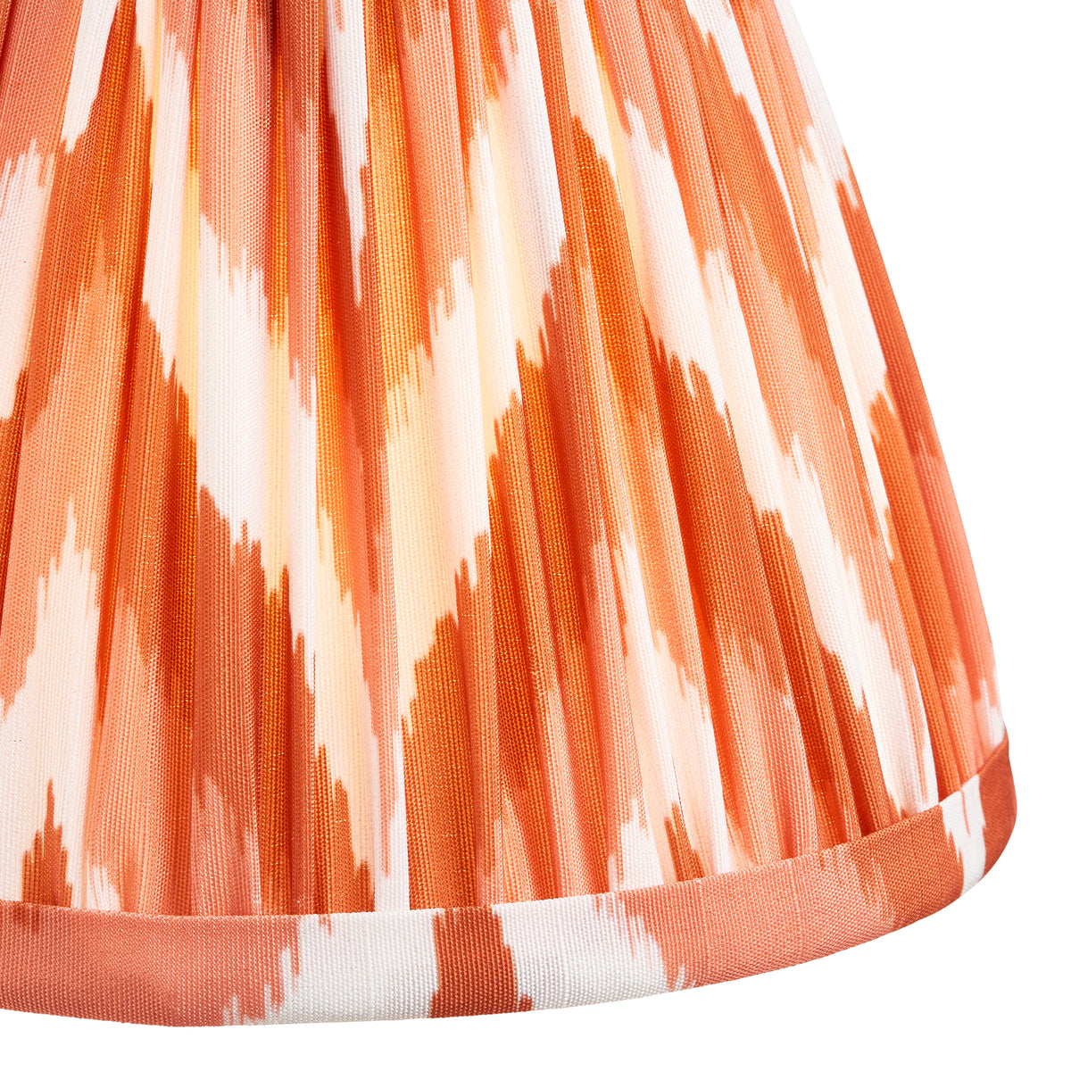 Close-up of pleated orange and cream ikat fabric with a bound lower edge