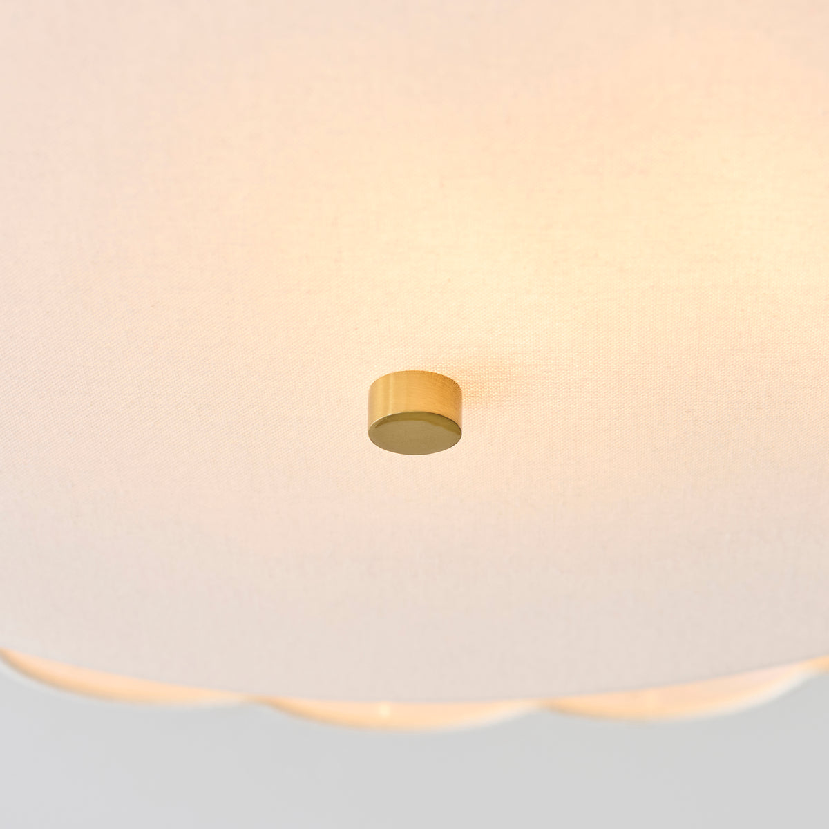 Detail of the brass finial on the glowing fabric diffuser of the Serene ceiling light