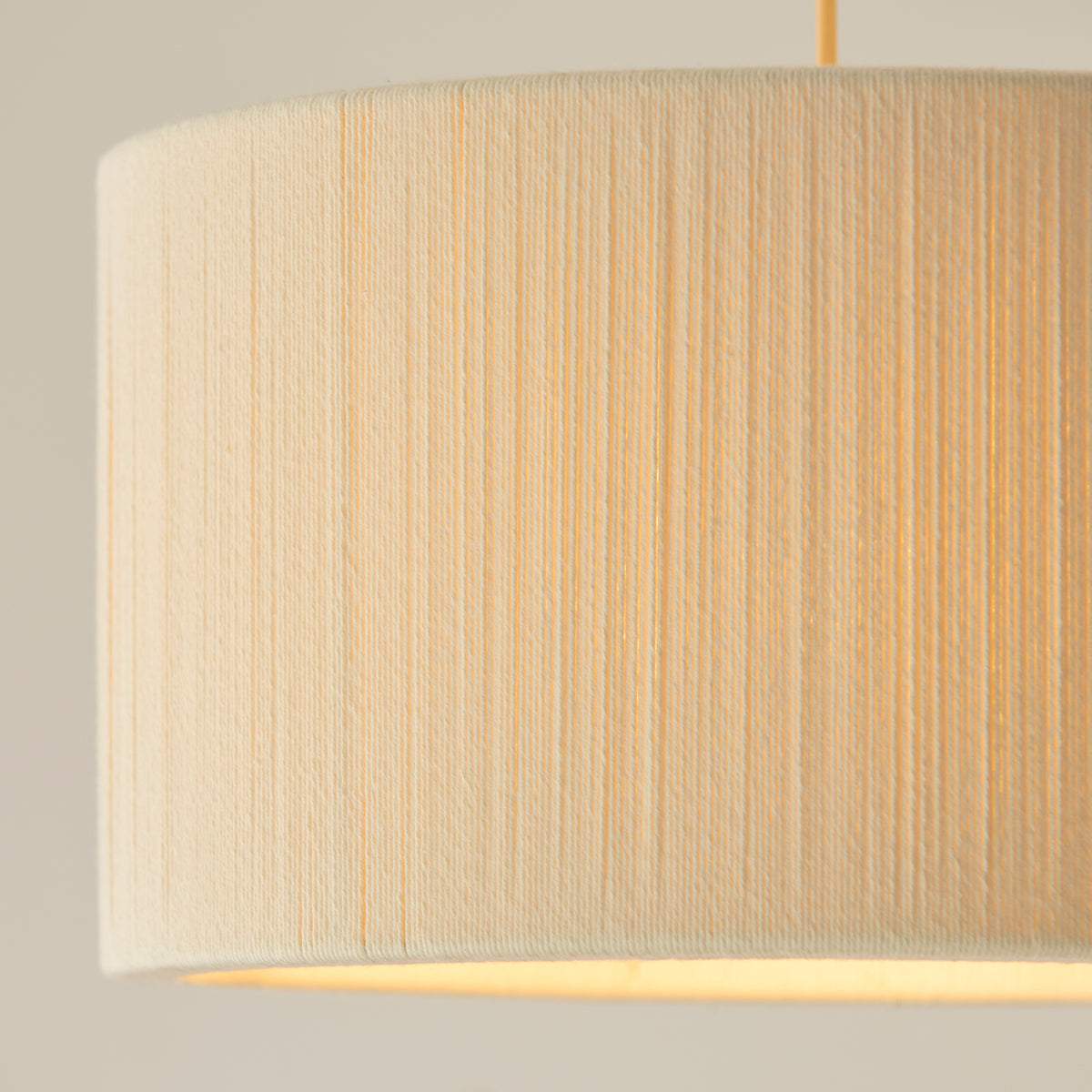 Close-up of the Noah pendant's vertically wrapped cream thread drum shade