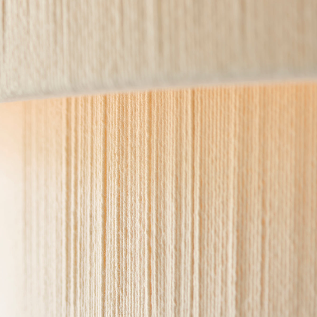 Macro detail of the wrapped cream threads on the Noah pendant's tiered shade