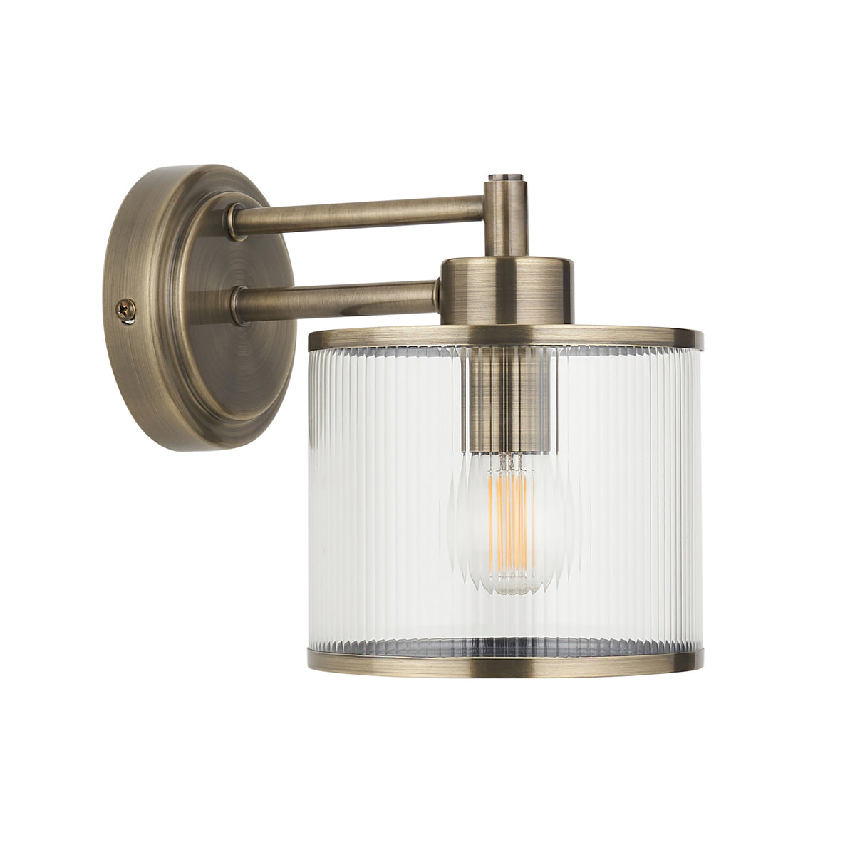 Ridgeton antique brass wall light with clear ribbed glass shade, lit on a plain background