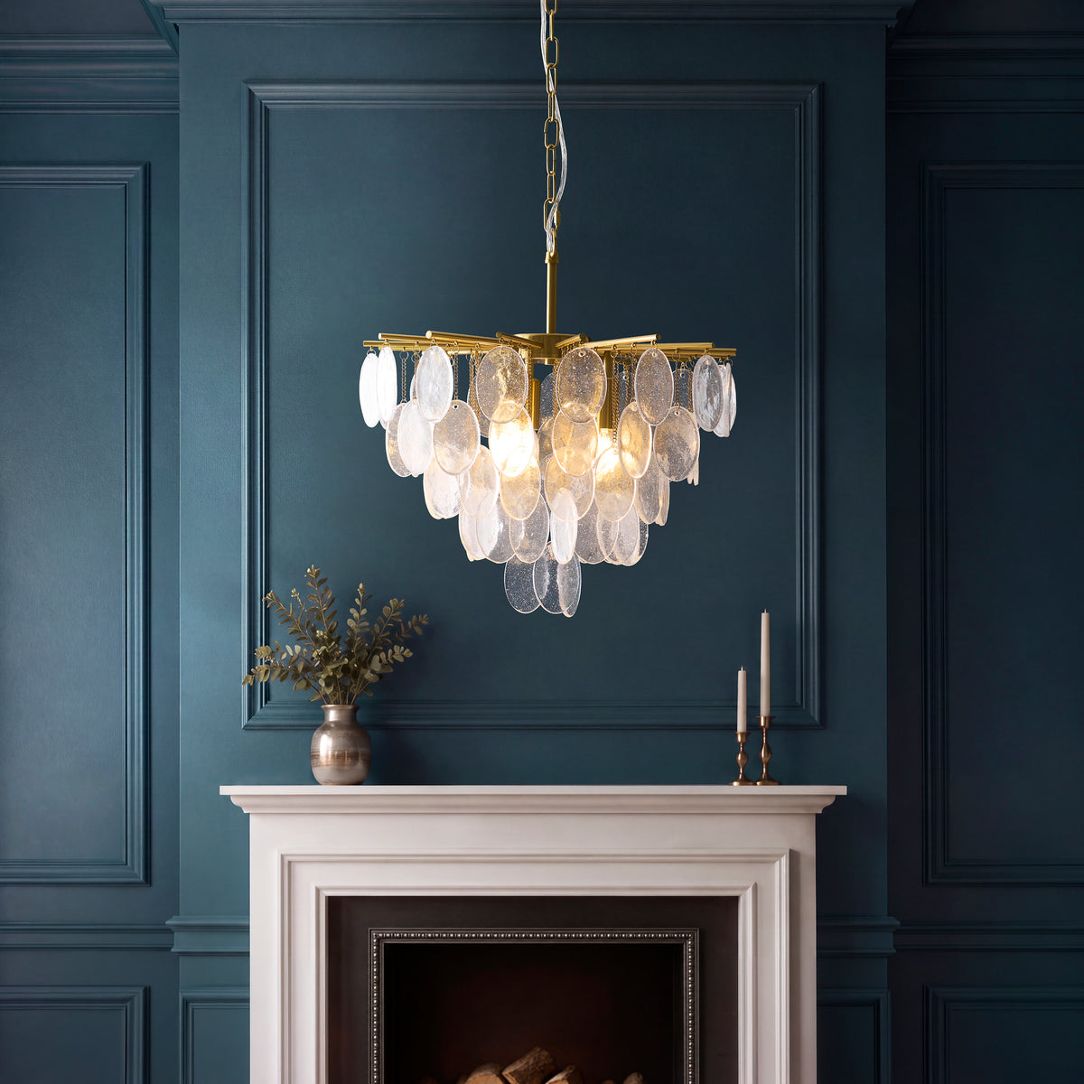 Loretta bubble glass pendant lit above a white fireplace in a dark teal panelled room