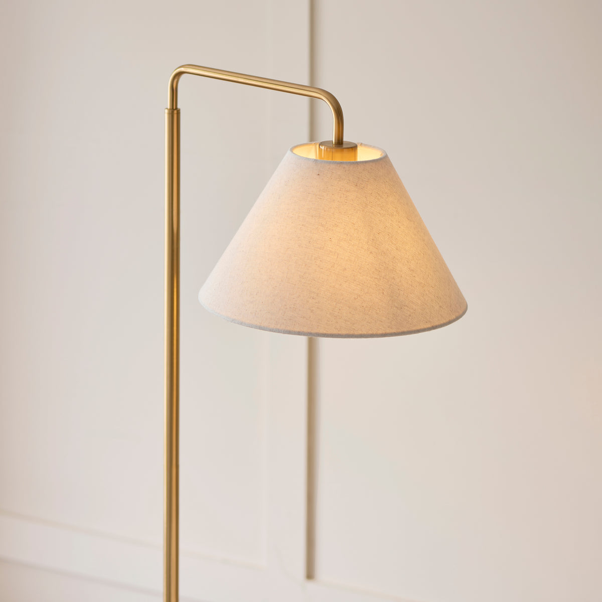 Close-up of the Wallbridge floor lamp's textured linen coolie shade and brass arm