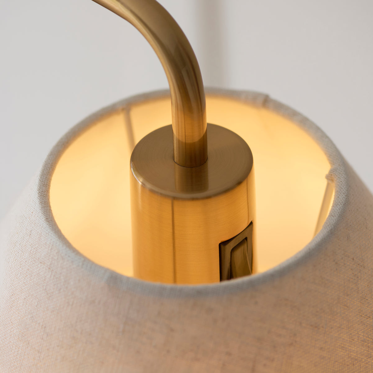 Detail inside the Wallbridge floor lamp's shade showing the brass lamp holder and switch