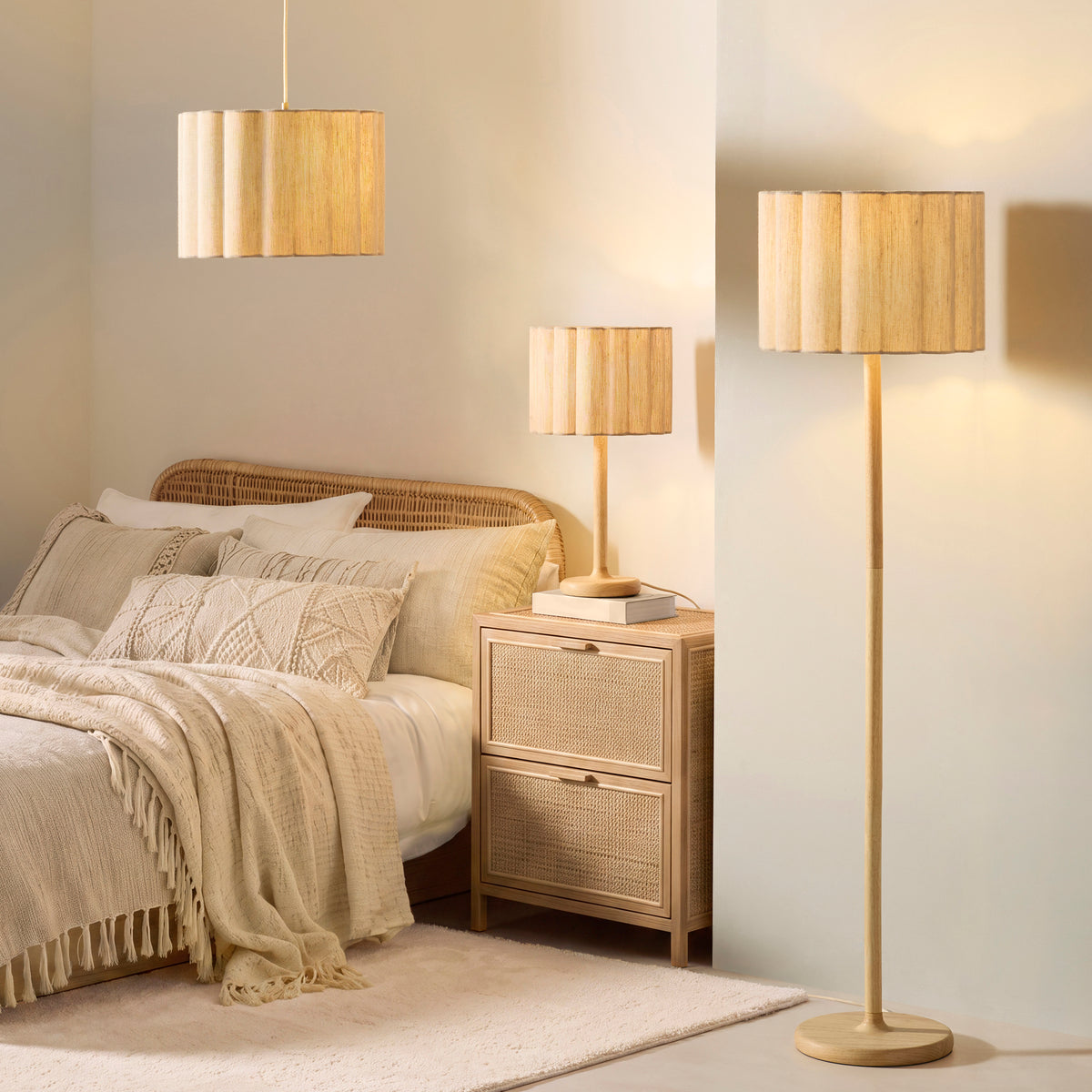 Bedroom lit by matching Olson scalloped shade pendant, table lamp and floor lamp in natural wood tones