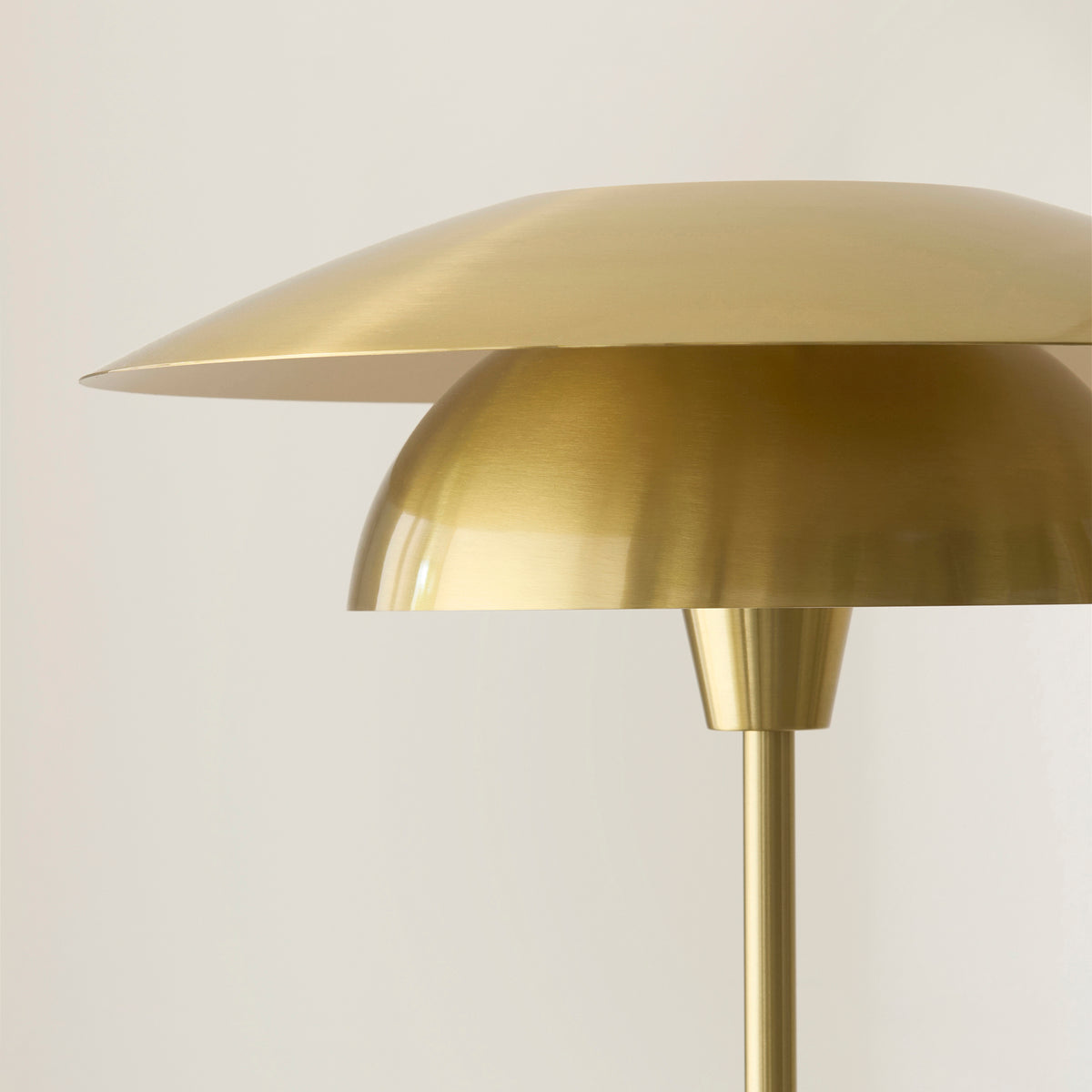 Close-up of the Lyon floor lamp's brushed brass upper disc and domed inner shade