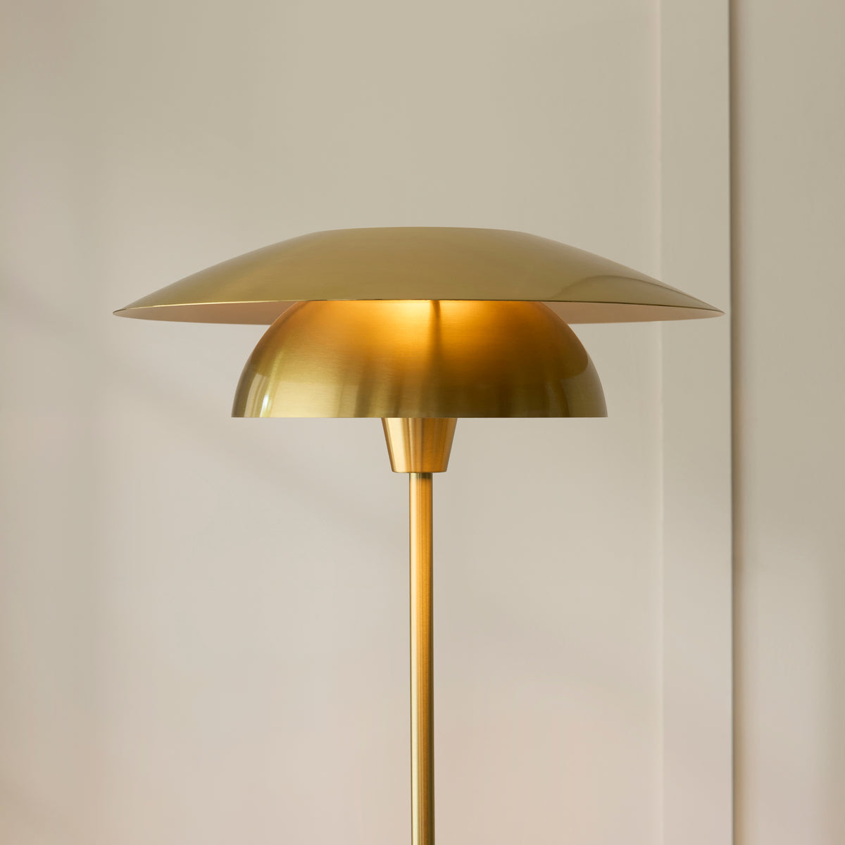Lyon brass layered shade lit warmly against a soft cream wall