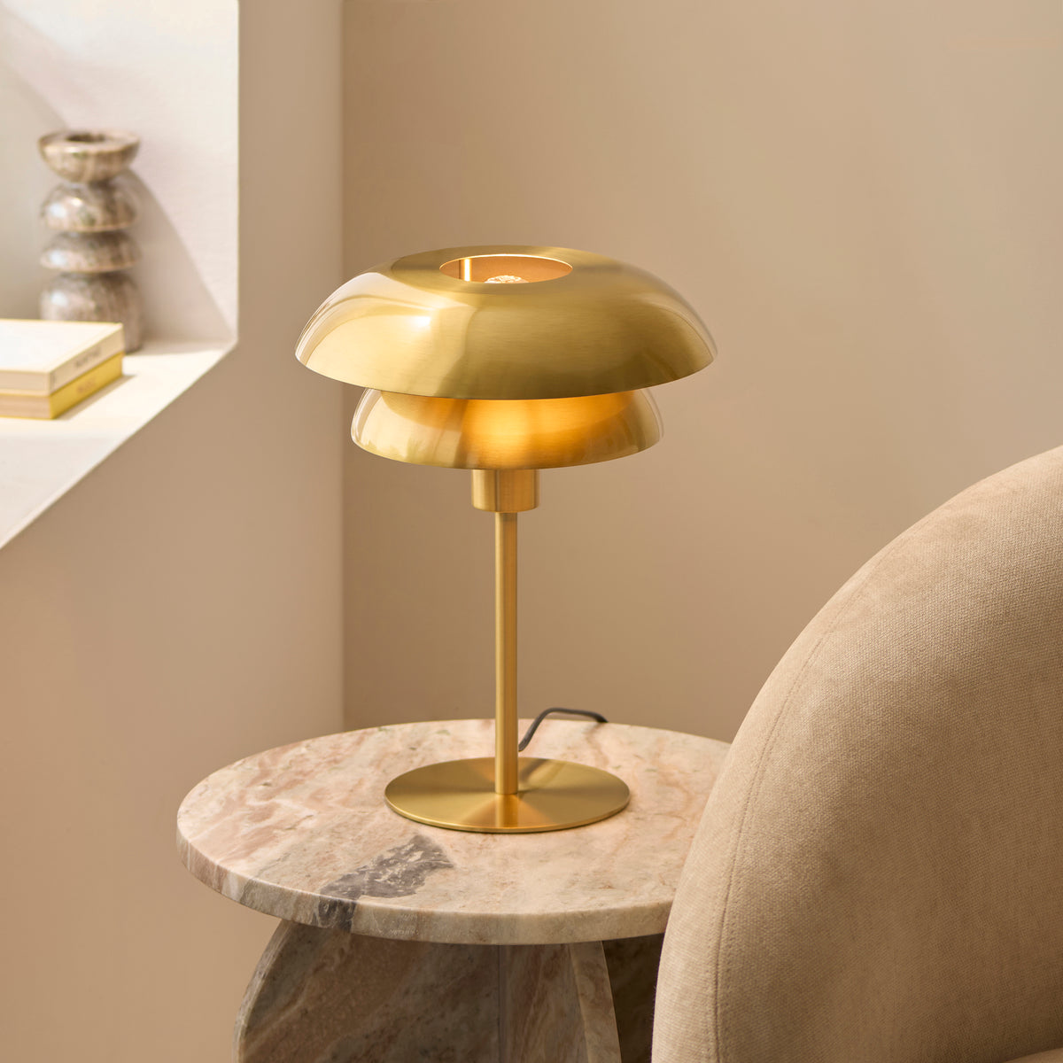Lyon satin brass table lamp on a marble table in a softly lit panelled room