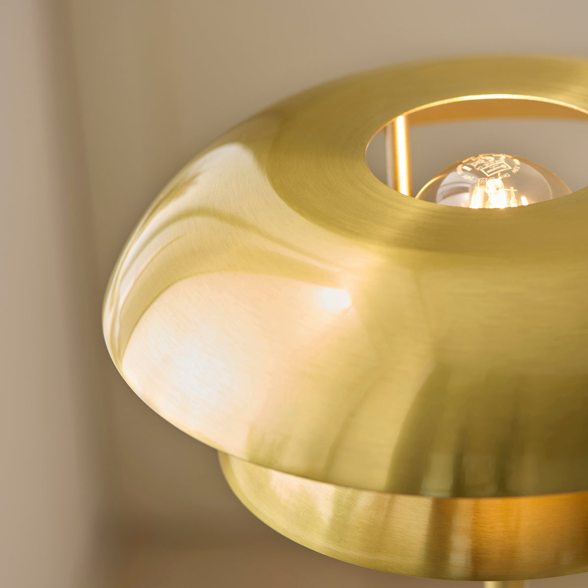Close-up of the filament lamp visible through the Lyon brass shade's top aperture