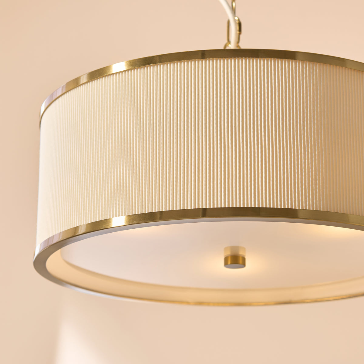Lexi pendant seen from below, showing pleated ivory shade, brass rim and glass diffuser