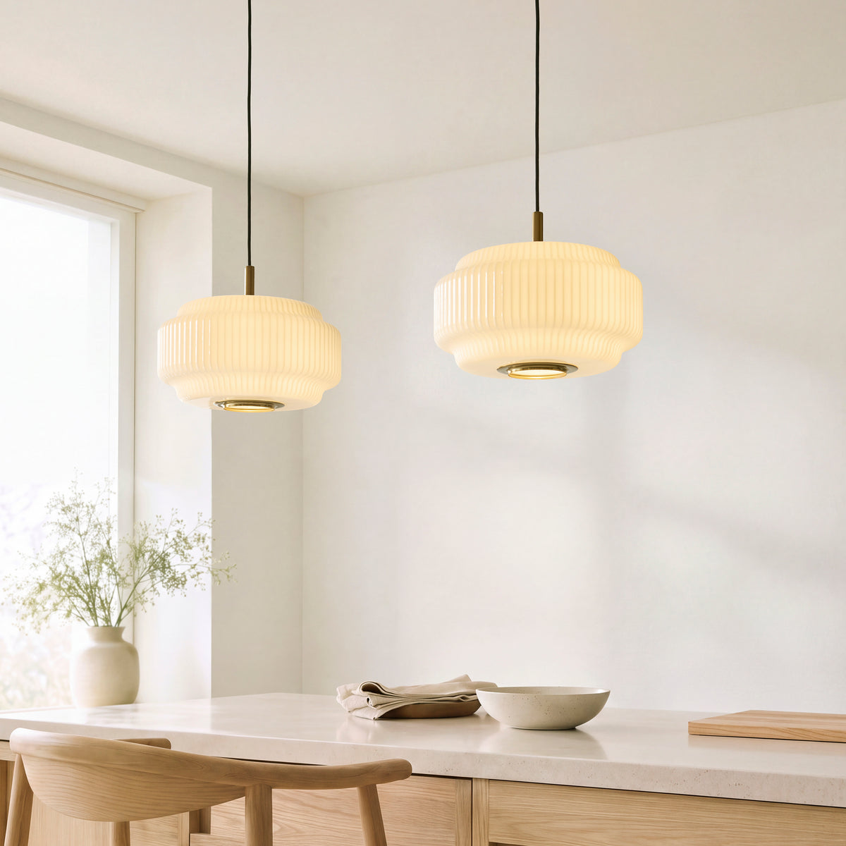 Two Evora ribbed opal glass pendants hanging over an oak dining table in a bright room