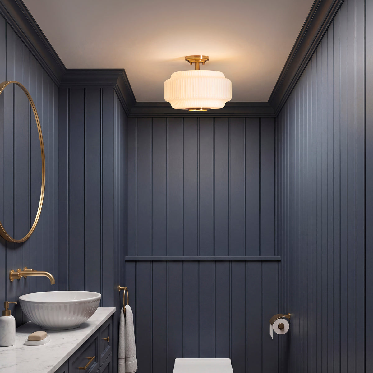 Evora flush ceiling light glowing in a dark panelled cloakroom with a round mirror and basin