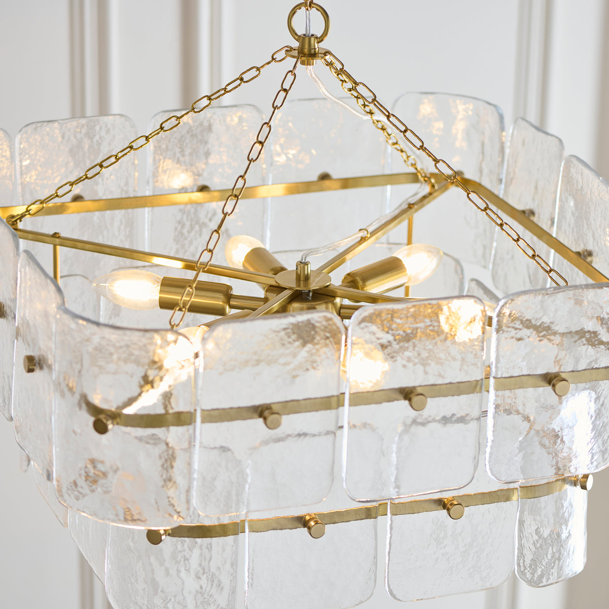 Top view of the Venice pendant's brushed brass frame, chains and candle lamps