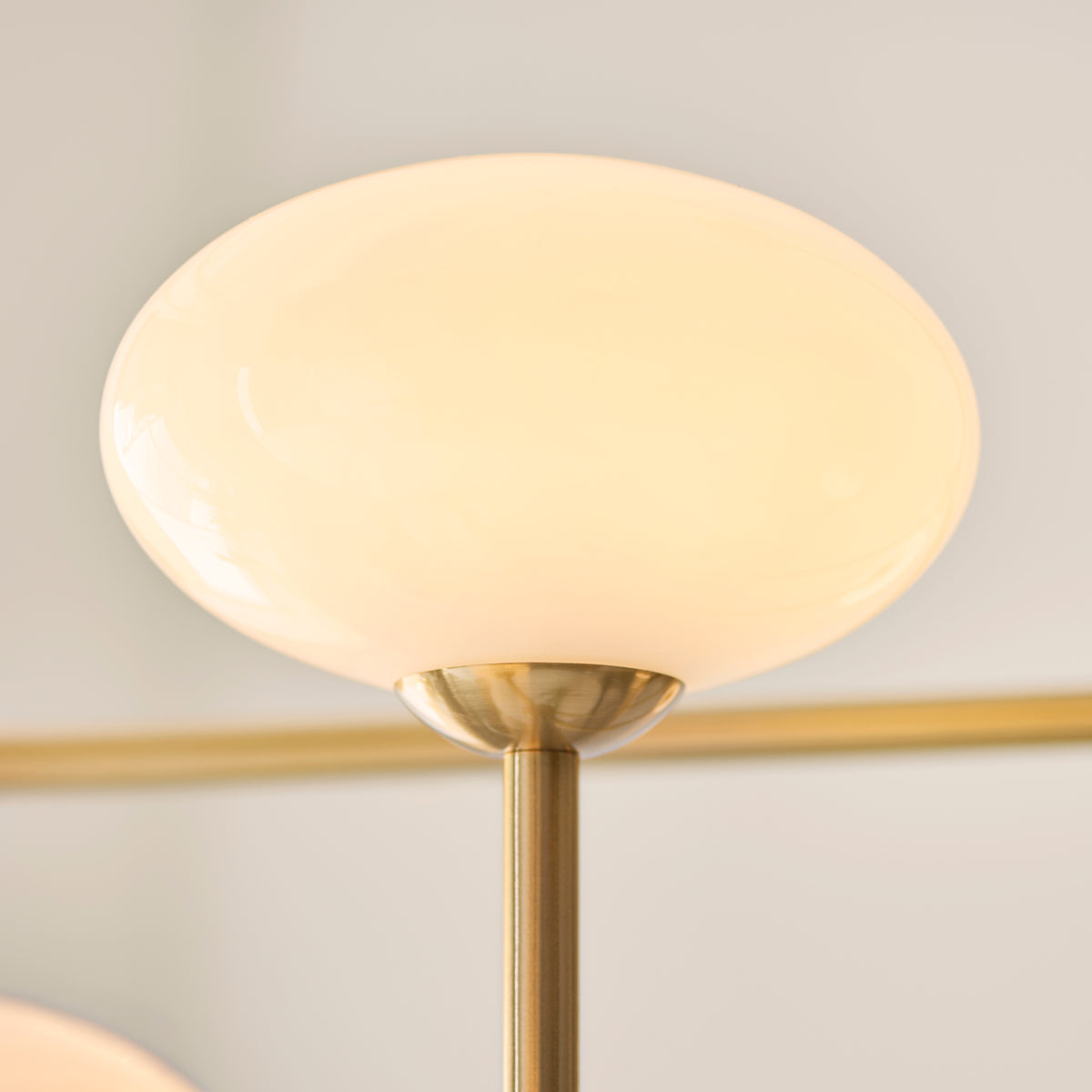 Detail of an oval opal glass shade capped in brushed aged brass on the Ottowa pendant