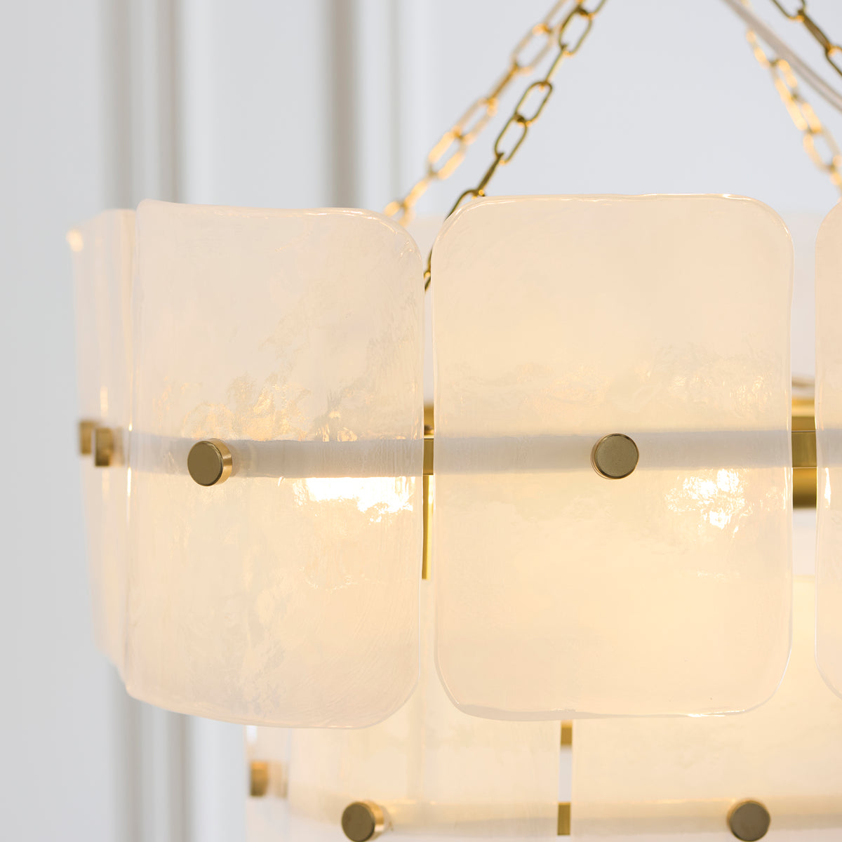 Detail of the Venice pendant's mottled white glass panels fixed with round brushed brass studs