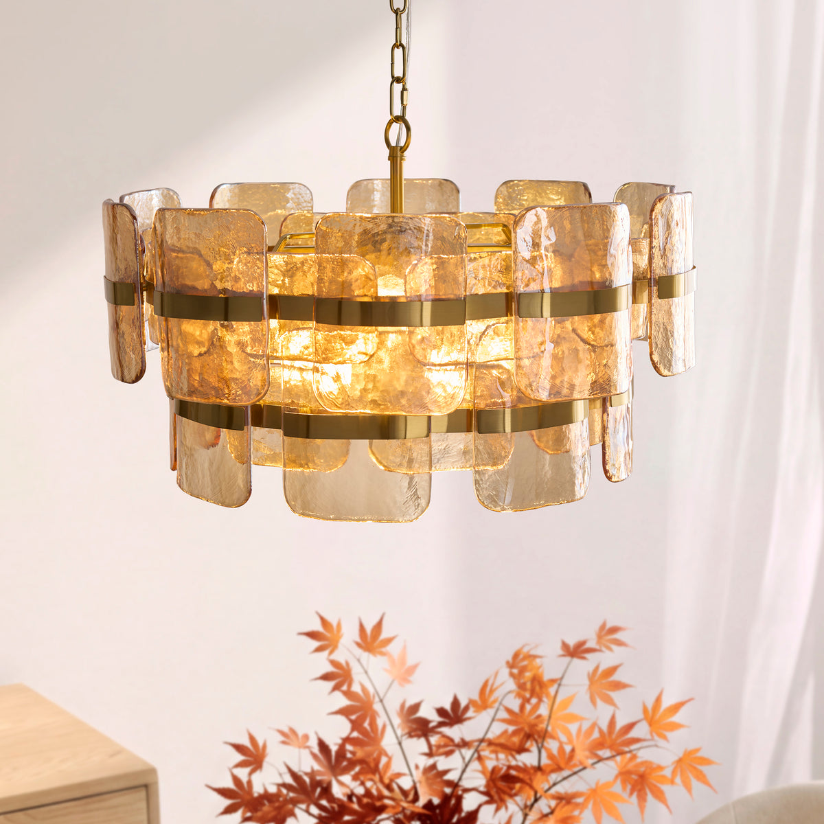 Ancara 6 light pendant glowing in a sunlit dining room, brass-banded champagne glass panels layered