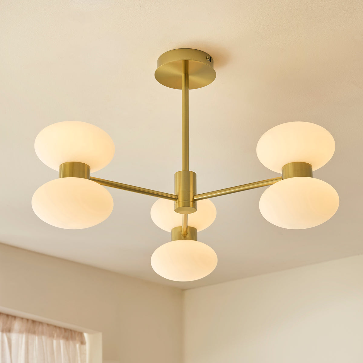 Rossano brass ceiling light fitted close to a white ceiling with opal glass shades glowing