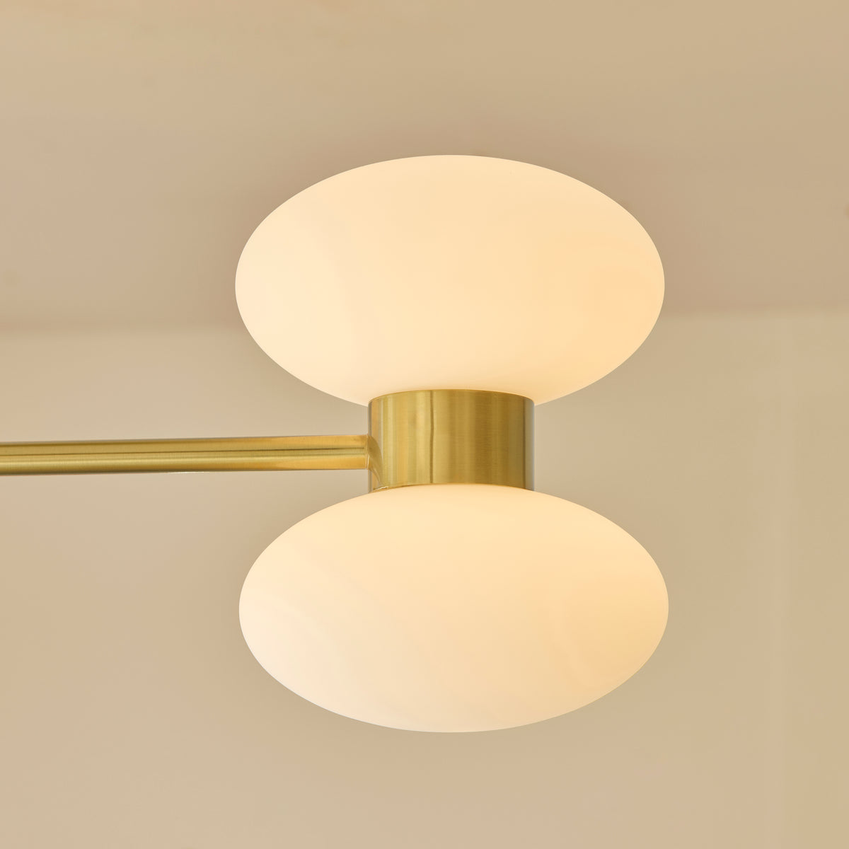 Close-up of the Rossano ceiling light's brass ceiling plate and central drop rod