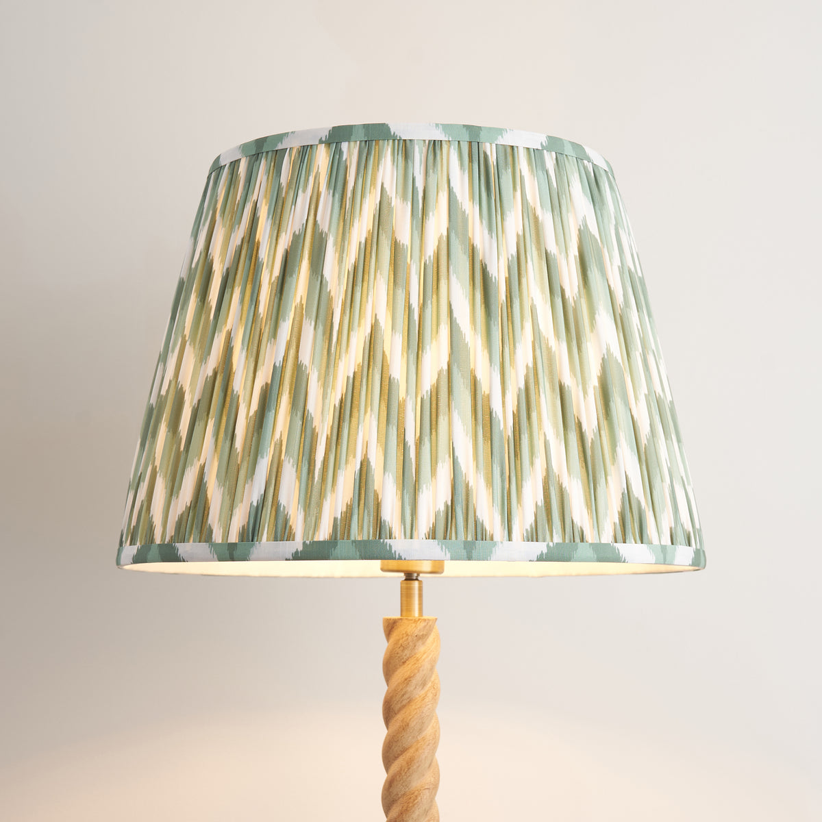 Close-up of the pleated green and cream zigzag shade above the twisted oak effect stem