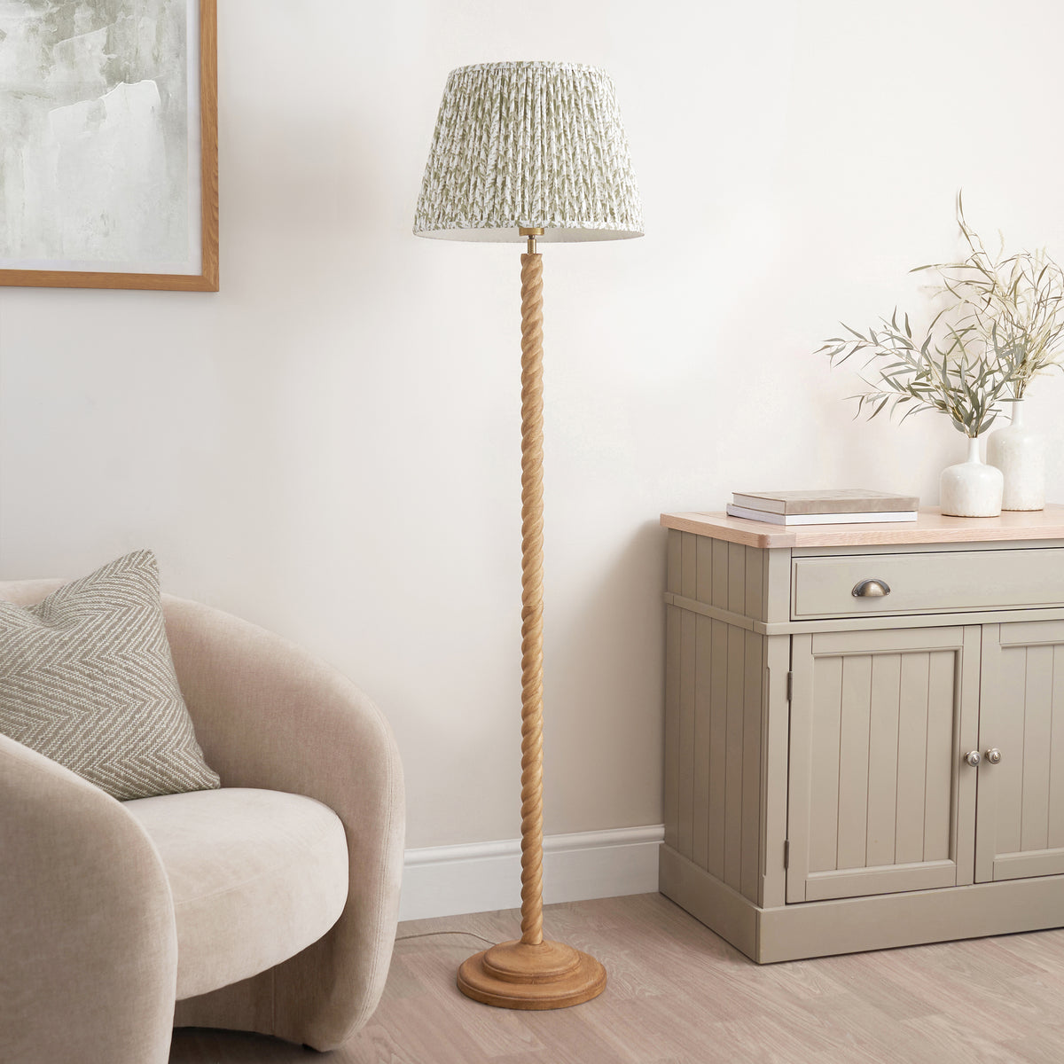 Oak effect twisted floor lamp with leaf patterned shade in a calm neutral living room