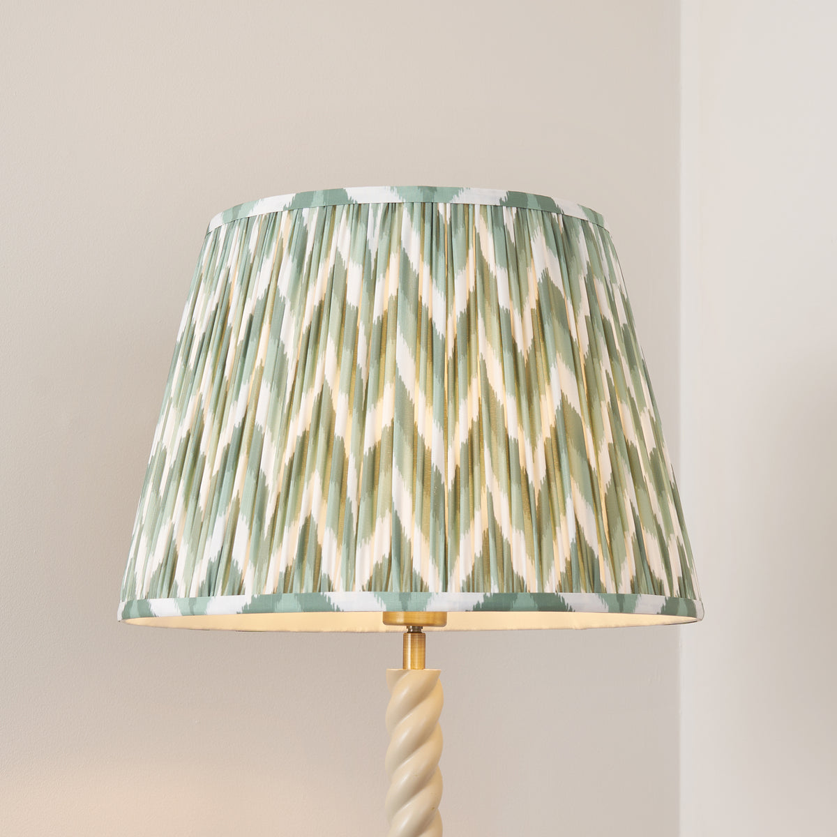 Close-up of the pleated green zigzag shade above the cream barley twist stem