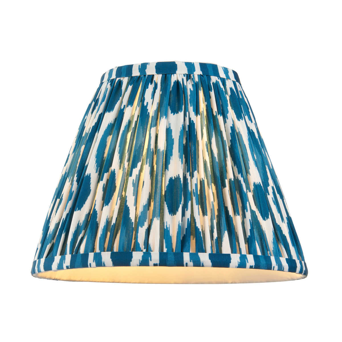 Pleated tapered lampshade in blue and cream ikat fabric, lit from within