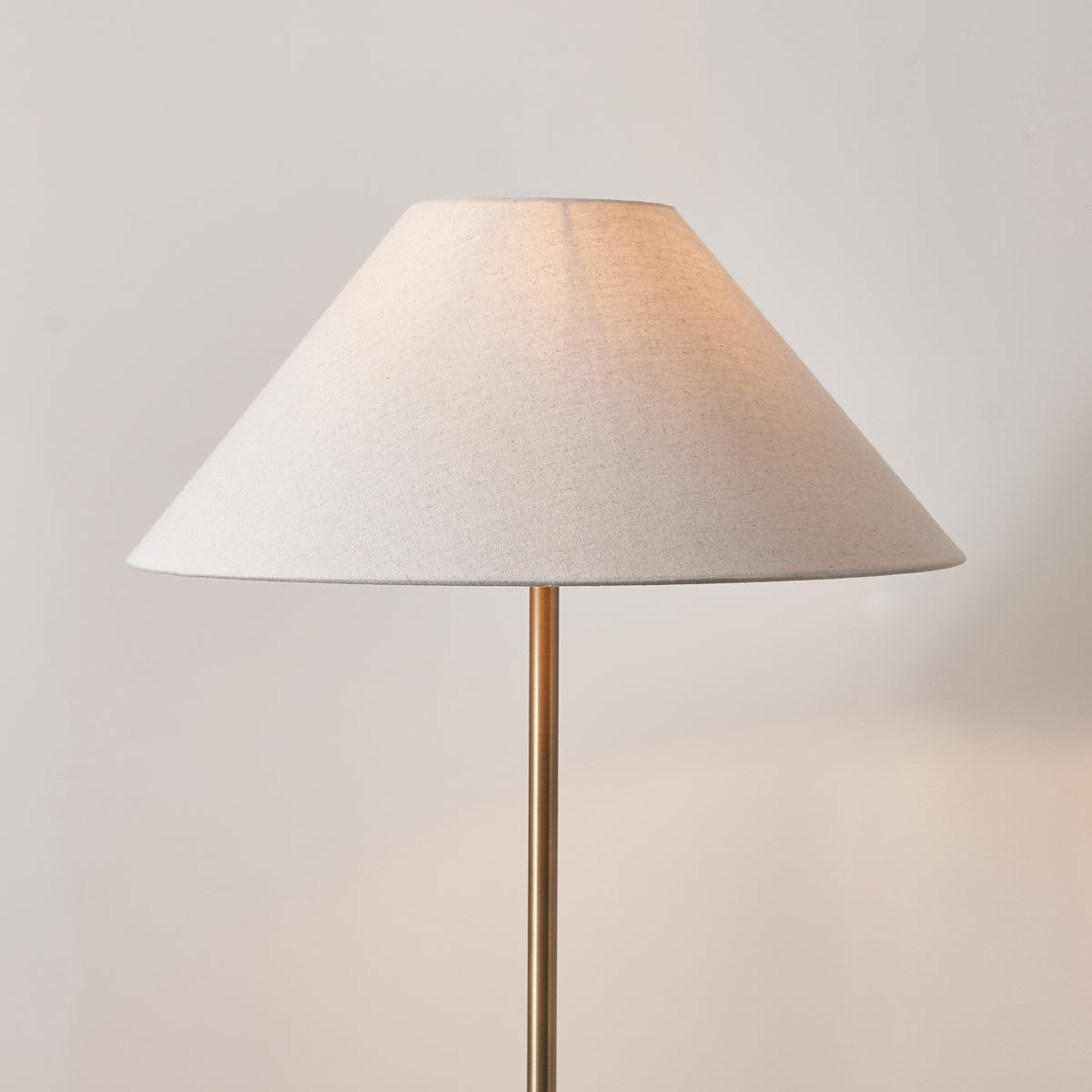 Close-up of the natural linen coolie shade above the antique brass Arlo stem