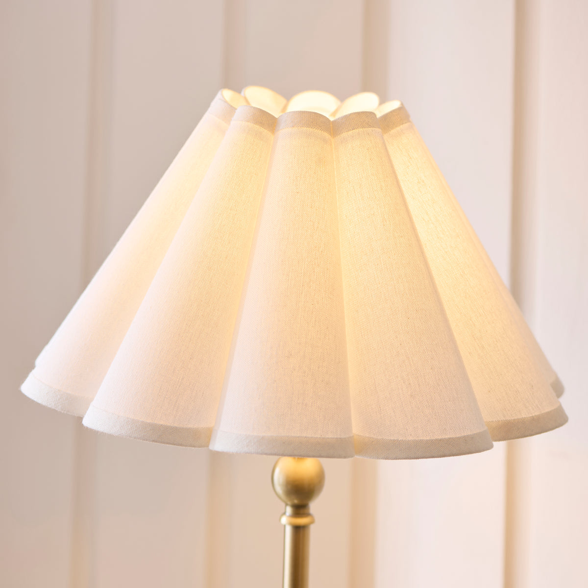 Close-up of the scalloped white shade and brass ball detail on the Sylvie table lamp