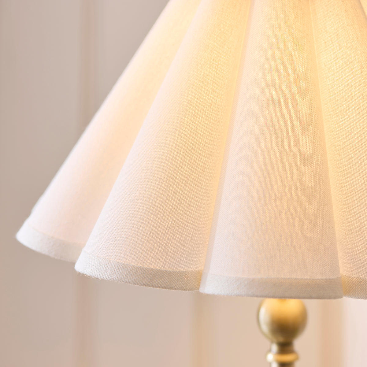 Detail of the softly lit pleated linen shade on the Sylvie brass table lamp