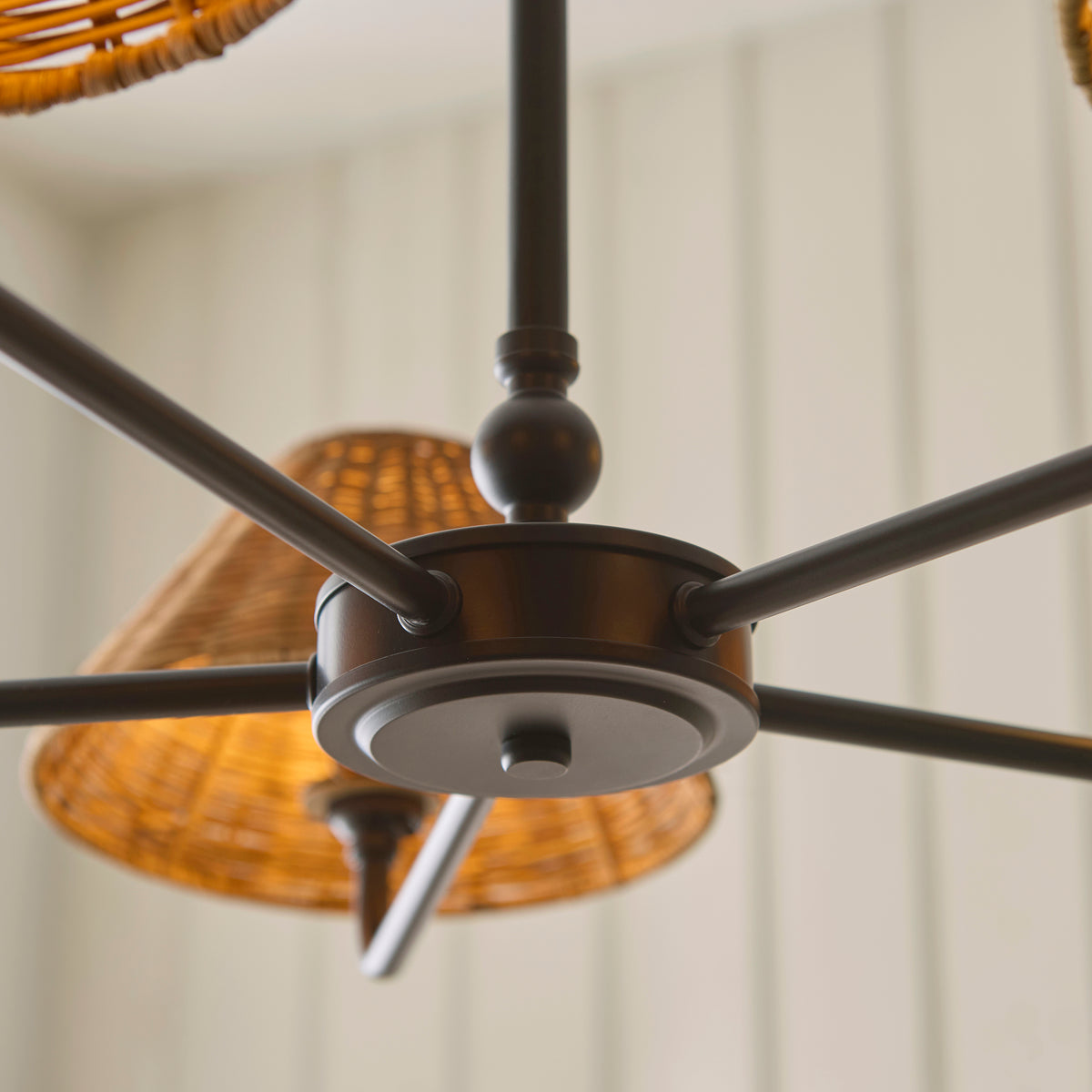 Underside view of the Jericho black pendant hub, arms and lit rattan shades