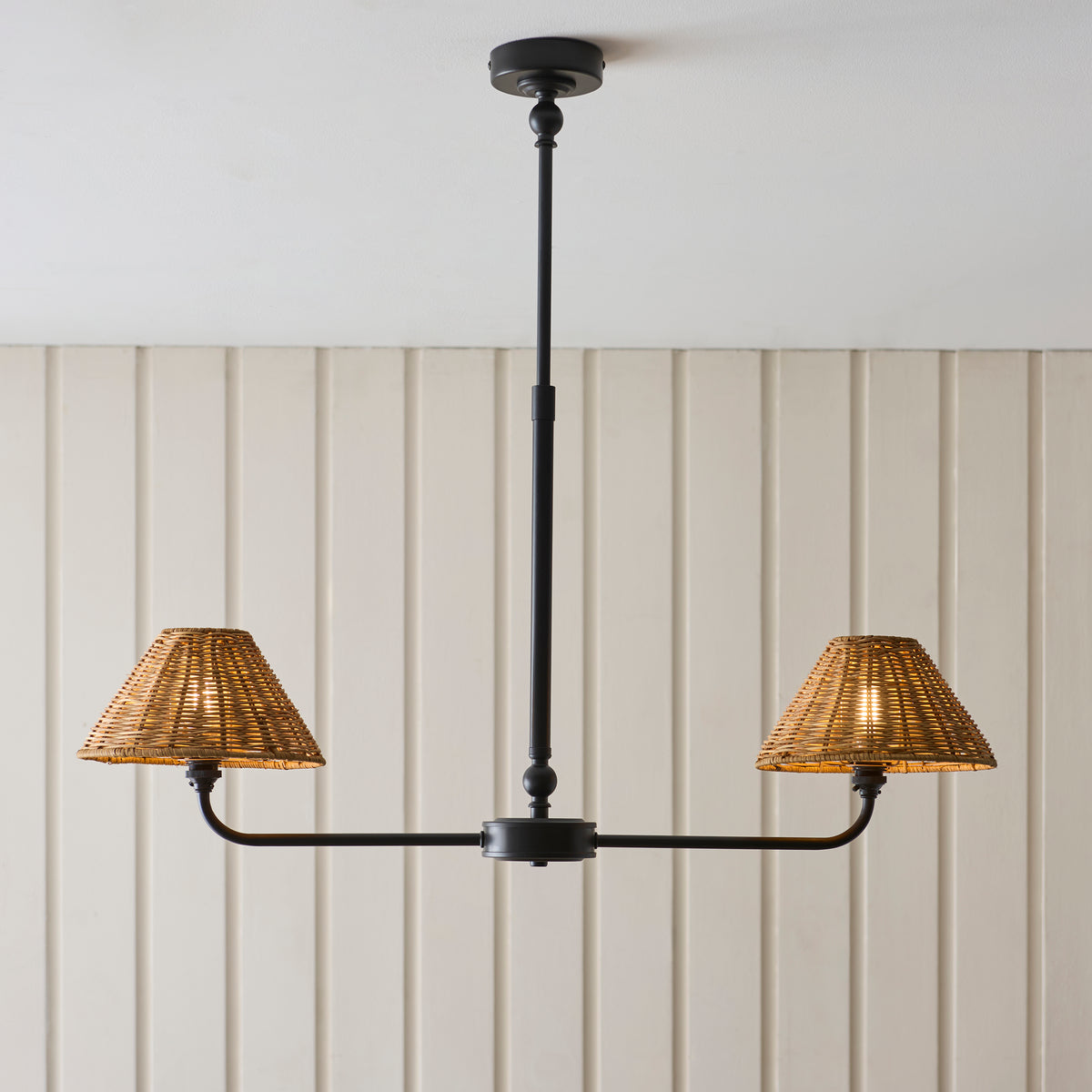 Two-light Jericho black linear pendant with rattan shades below a white ceiling