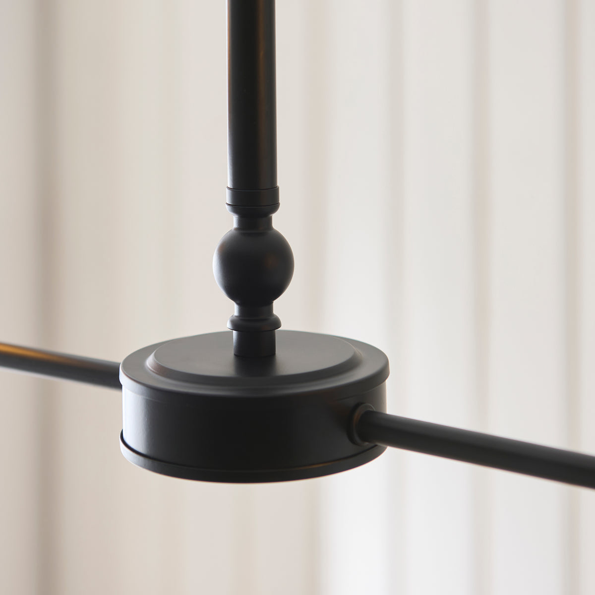 Detail of the Jericho linear pendant's matt black hub with turned ball above