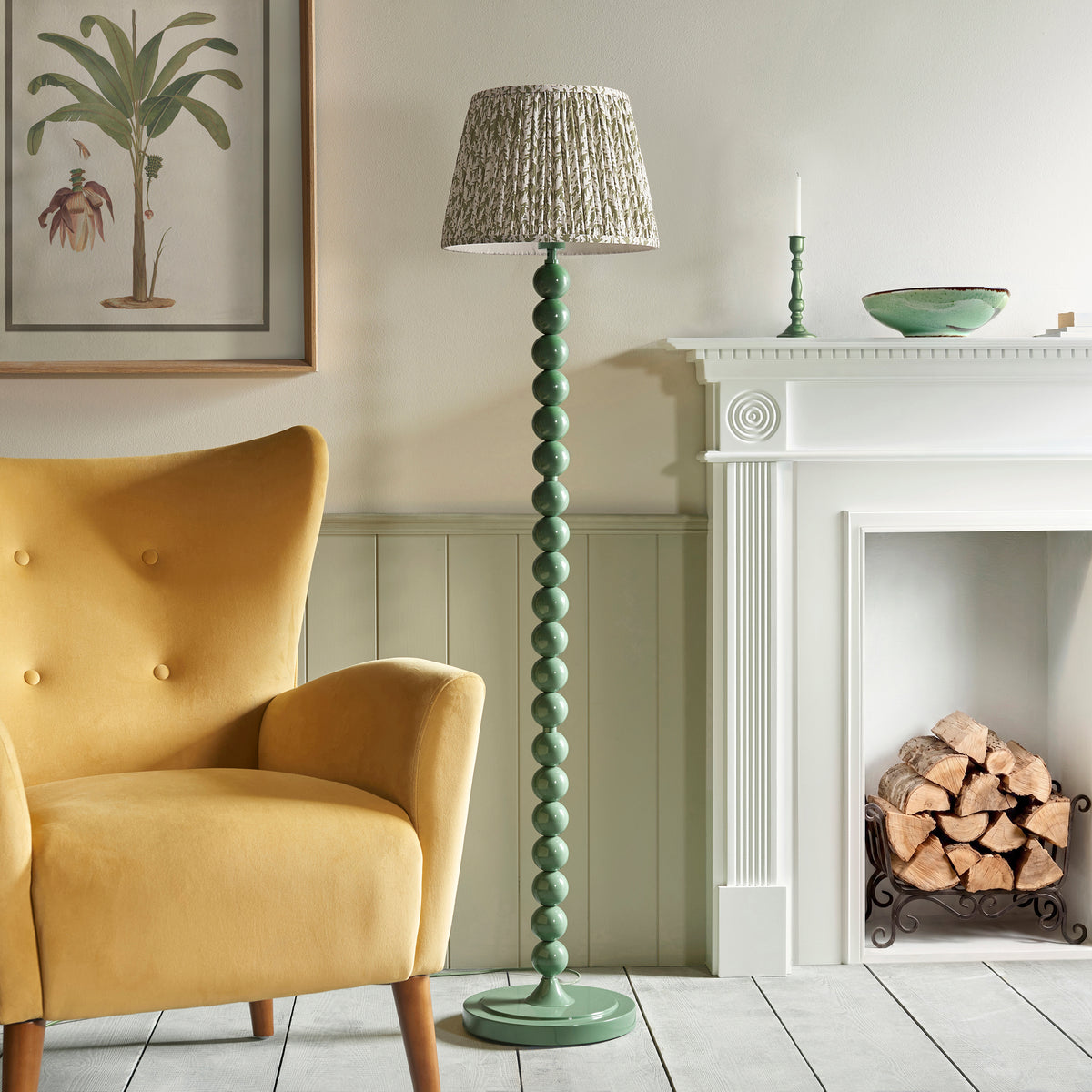 Higgledy & Leaf floor lamp unlit next to a mustard velvet chair and log-filled fireplace