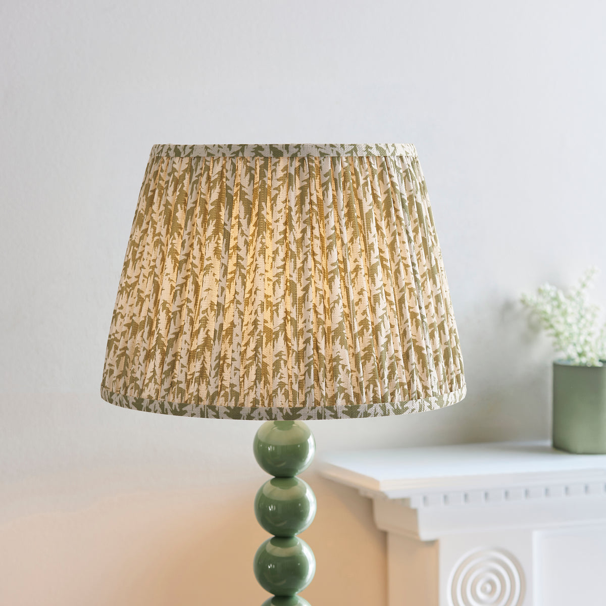 Close-up of the pleated green leaf shade above the Higgledy lamp's green ball stem