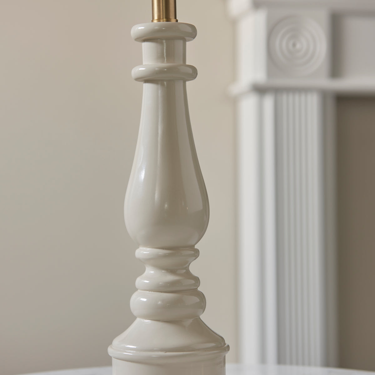 Detail of the turned almond white Myrtle lamp base against a pale wall