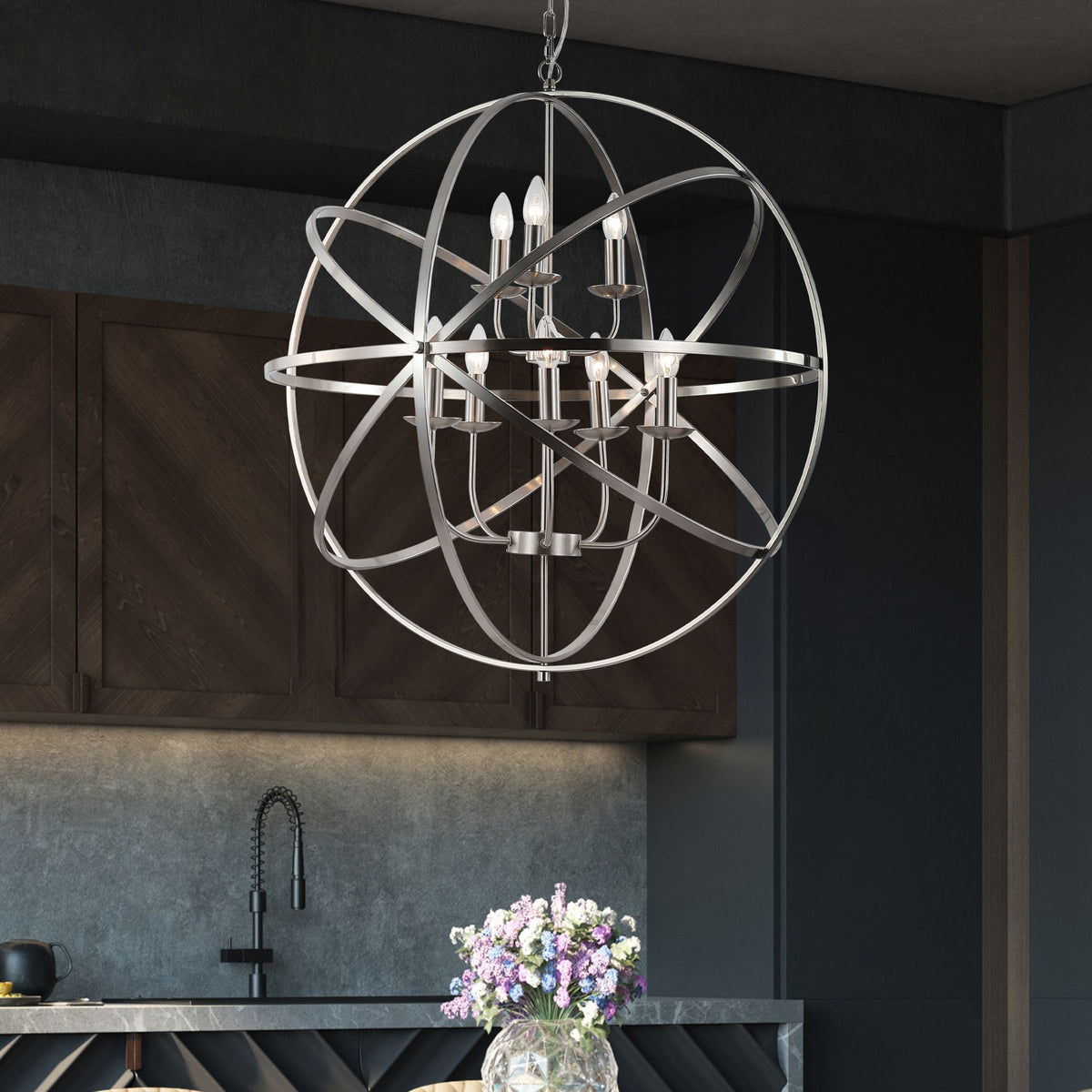 Dark kitchen with the Orbit silver cage chandelier above an island with flowers and tap