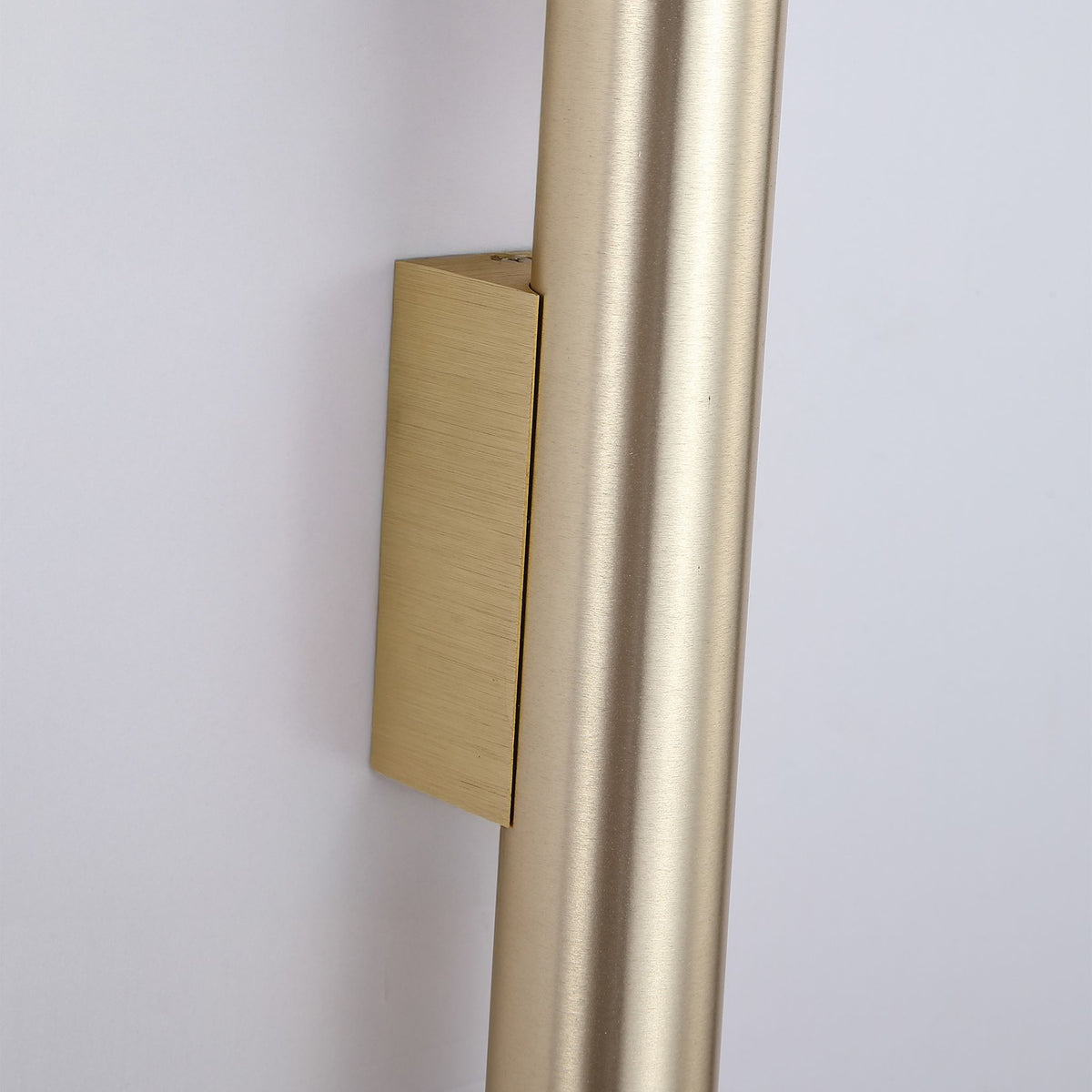Close-up of the Beacon tube's brushed gold surface and square wall bracket