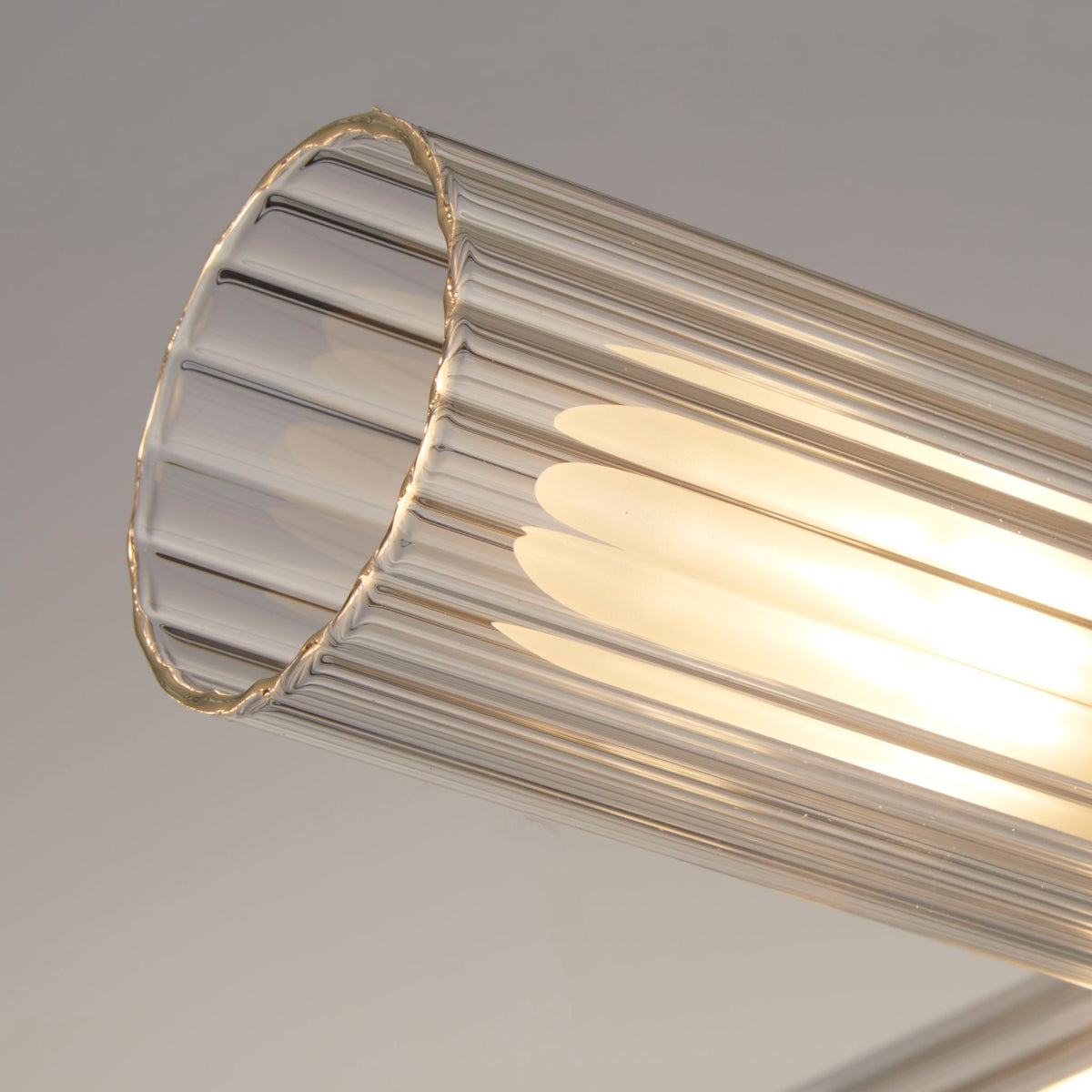 Close-up of one ribbed clear glass cylinder shade on the Imperial ceiling light showing its LED tube