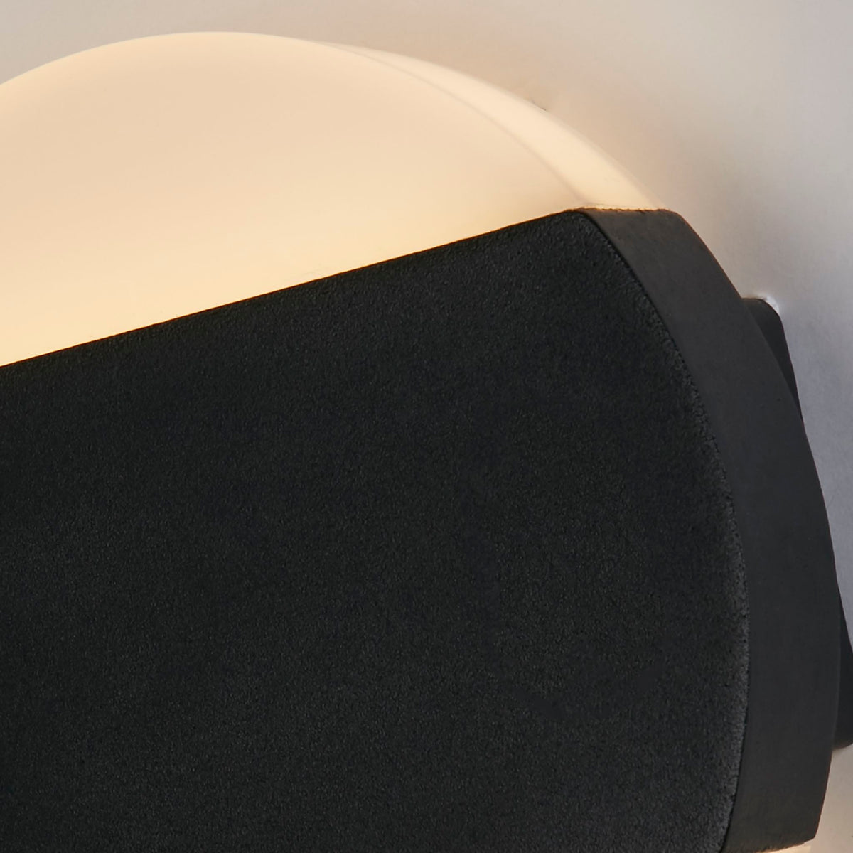 Close-up of the Cavern disc's textured black band and softly glowing white diffuser