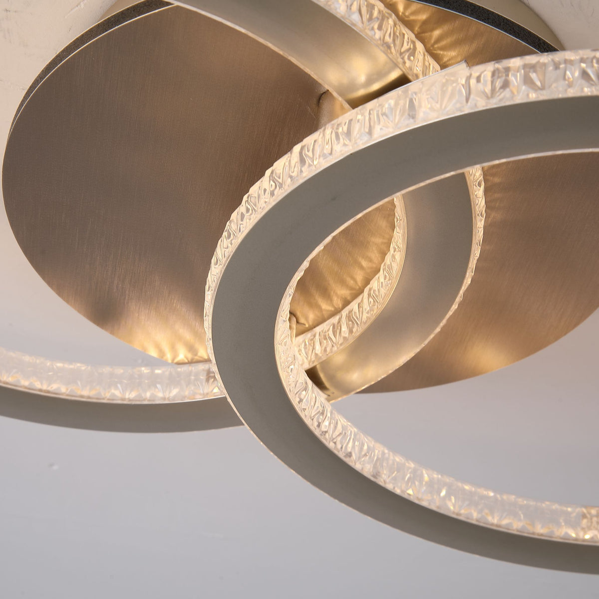 Close-up of Specs ceiling light's textured crystal-effect rings and brushed champagne backplate