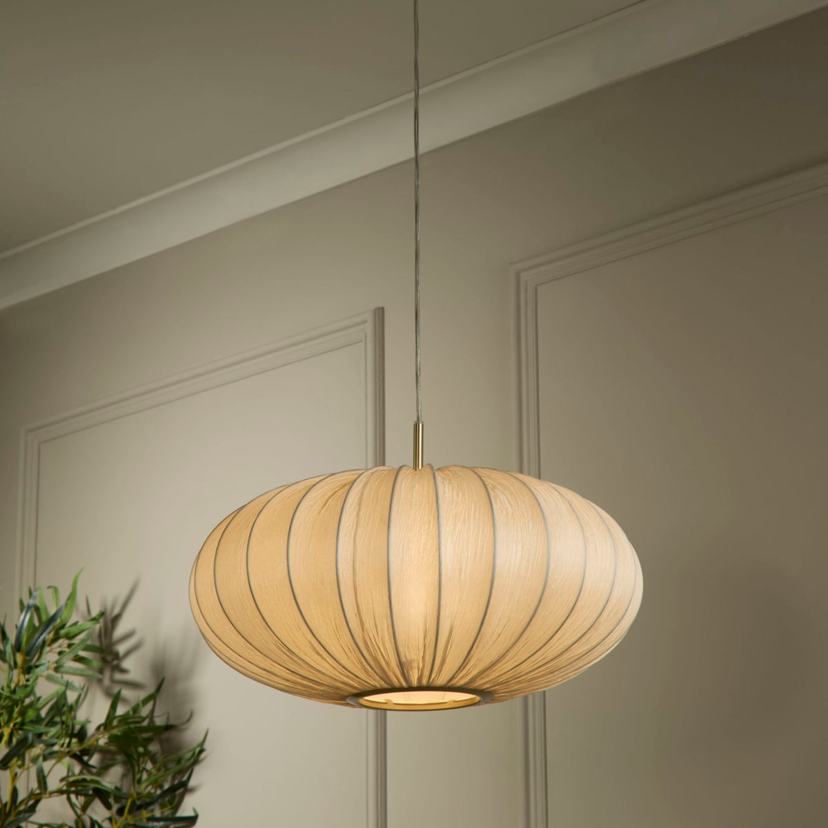 Bonnie ivory pendant hanging by sage panelled walls with olive foliage below