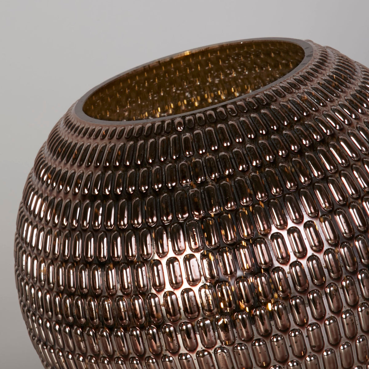 Close-up of the Mila lamp's dimpled bronze glass globe and open top rim