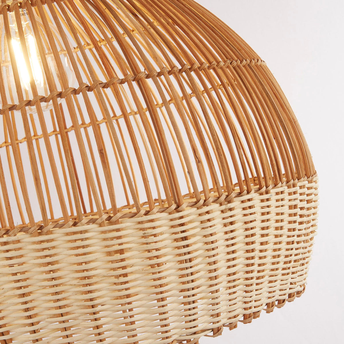 Close-up of the Bali shade's rattan slats above a tightly woven cream basket weave