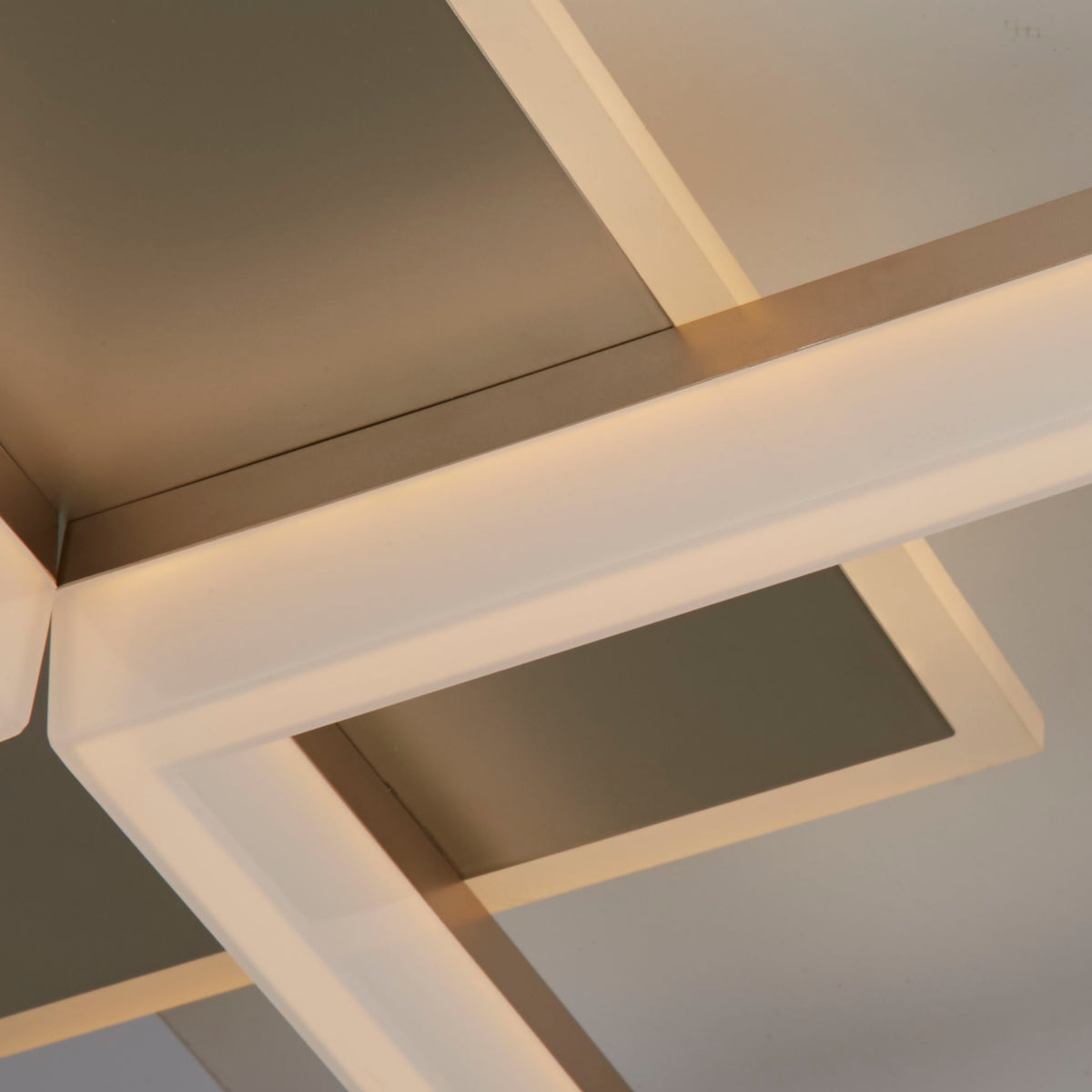 Close-up of the Fence ceiling light's brushed gold frames and glowing opal LED edges