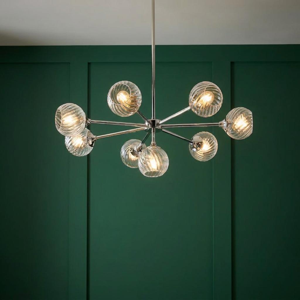 Allegra 8-light nickel pendant with illuminated swirled glass globes against a dark green wood-paneled wall.