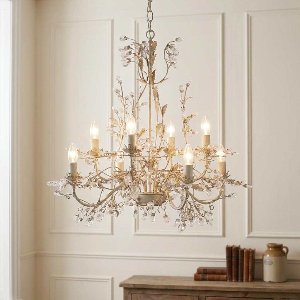 Almandite 8-light chandelier in cream gold finish with crystal buds and candle lamps in a paneled room.