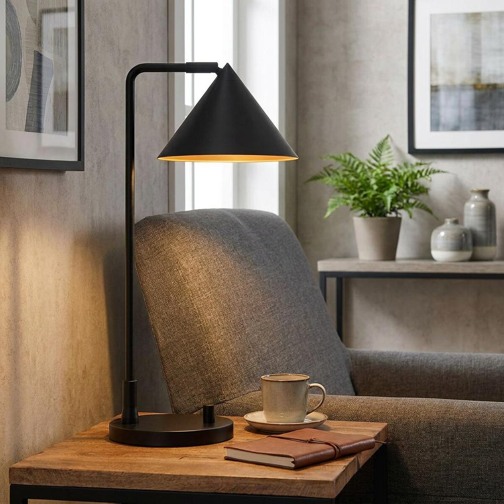 Black conical table lamp lighting a cozy reading nook with a grey armchair and wooden side table.